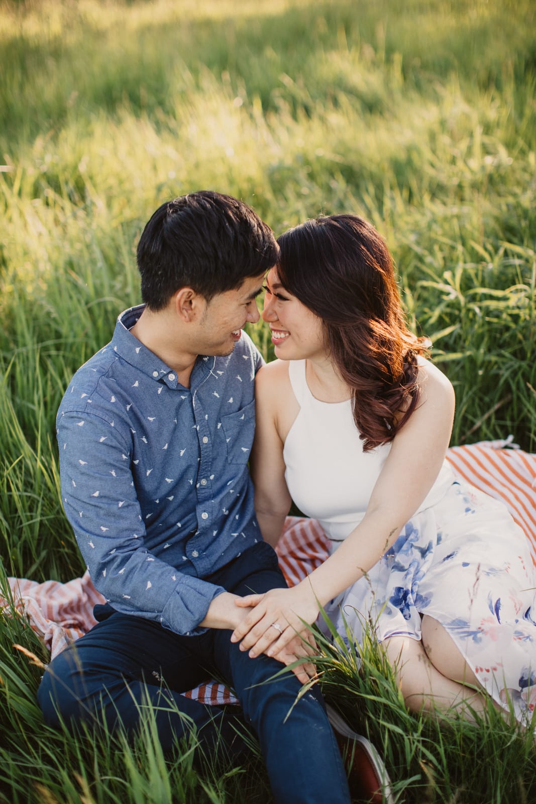 A Scotsdale Farm engagement session featuring an Asian couple sitting on a blanket in a field.