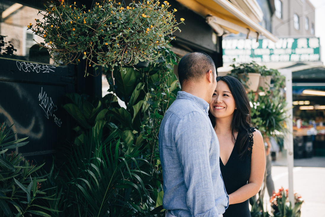 Couple laughing in front of plant shop | Kensington Market Engagement, Toronto | EightyFifth Street Photography