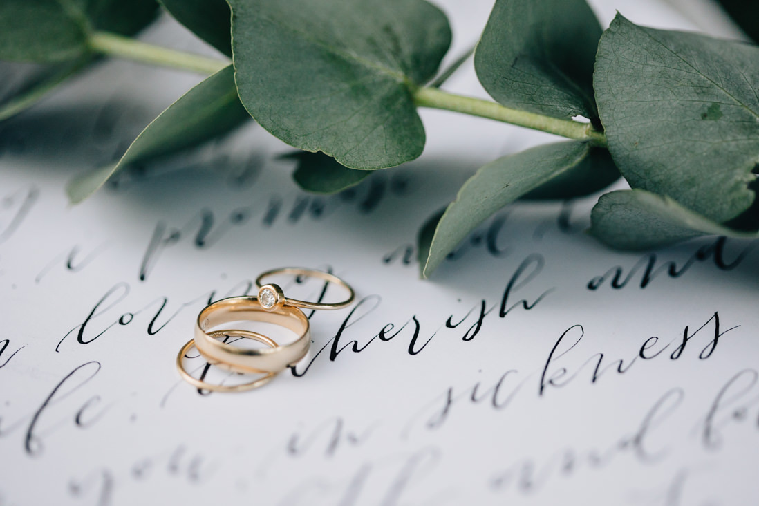 minimalist wedding rings on top of modern calligraphy vows | eightyfifth street photography