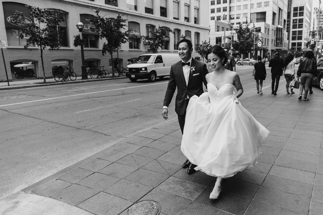 black and white bride & groom portrait walking on toronto streets