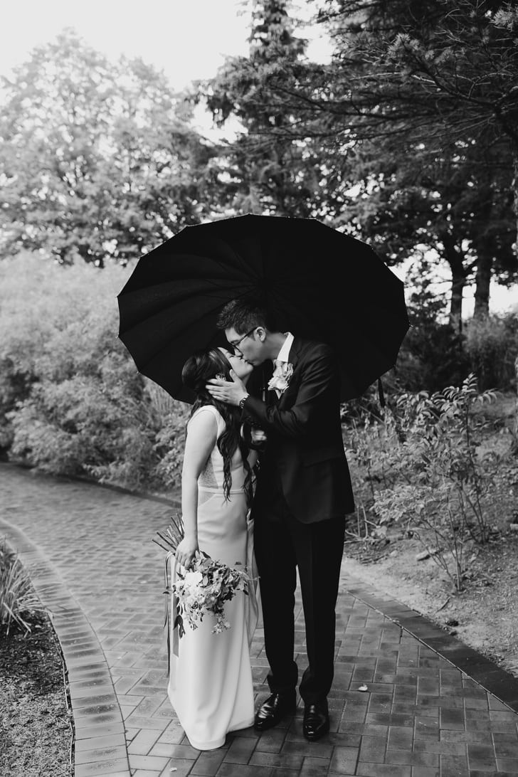 Arlington Estate wedding in Vaughan, captured in a black and white photo of a bride and groom kissing under an umbrella.