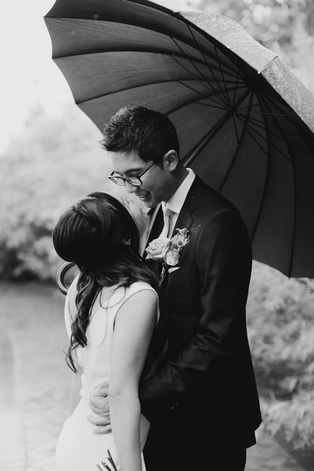 black white portrait of bride and groom under umbrella eightyfifth street photography