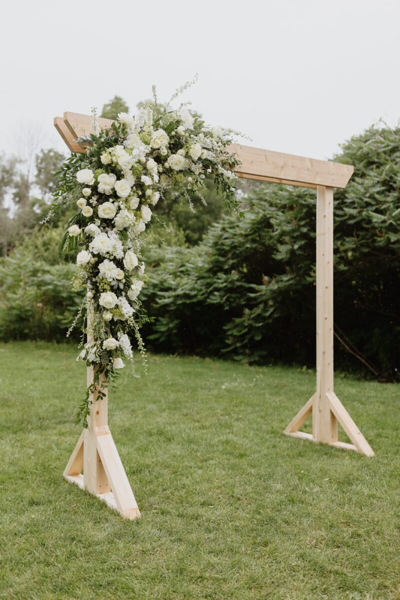 White floral arrangement on wooden frame by Forever Blooming set up for a Wedding Ceremony at Harding waterfront estate wedding in Mississauga.